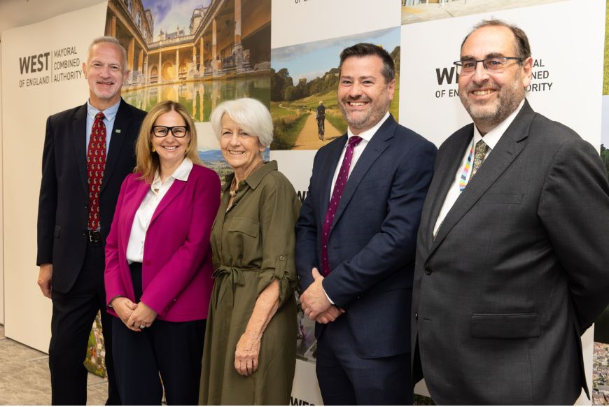 5 people in suits standing in front of WECA board